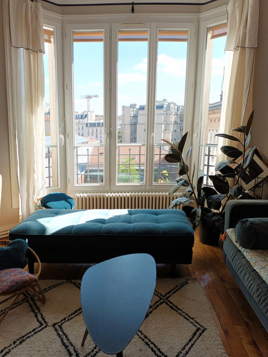 vista del salón sobre los tejados de parís con mesa de centro y sofá de diseño